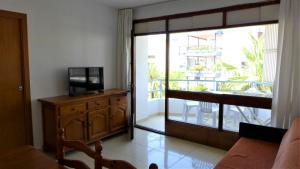 a living room with a tv and a sliding glass door at Apartamentos Colon in Salou