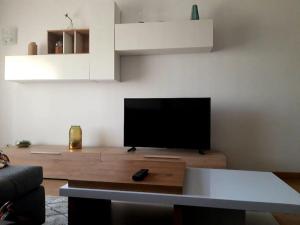 a living room with a flat screen tv on a wooden table at Amazing Apartments in Agualva
