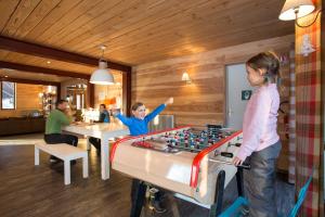 two children playing with a foosball table in a room at Huttopia Bourg St Maurice in Bourg-Saint-Maurice