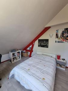 ein Schlafzimmer mit einem großen Bett im Dachgeschoss in der Unterkunft Charmante maison proche de Paris in Sainte-Geneviève-des-Bois
