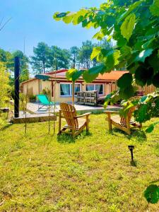 una casa con due sedie in legno nel cortile di BAOBAMBOU à 5 min de l'Océan a Vielle-Saint-Girons