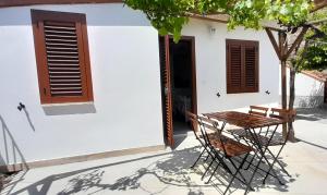 una mesa y sillas frente a una casa blanca en Arena Vacanze en Castellabate