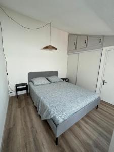 a bedroom with a bed in a white room at Petite maison de vacances au bord de l'eau in Leucate