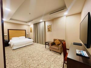 a hotel room with a bed and a desk and a chair at Grand Legacy Hotel Doha in Doha