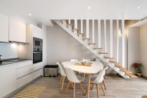 a kitchen and dining room with a table and stairs at A Casa da Elsa in Faro