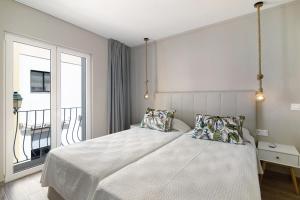 - une chambre avec un lit avec deux oreillers et une fenêtre dans l'établissement A Casa da Elsa, à Faro