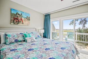 a bedroom with a bed and a large window at Windy Lane Leisure in Pawleys Island