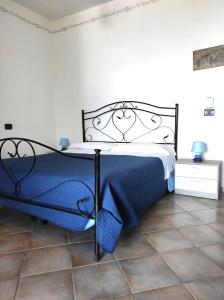 1 dormitorio con 1 cama con manta azul en Eoliano B&B, en Malfa