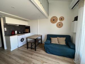 salon z niebieską kanapą i stołem w obiekcie Petite maison de vacances au bord de l'eau w mieście Leucate