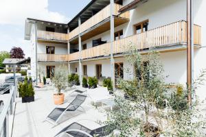 une terrasse extérieure dans un bâtiment avec des chaises et des arbres dans l'établissement Apartmenthotel Oberstdorf, à Oberstdorf
