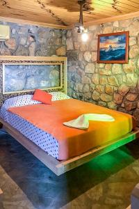a large bed in a room with a stone wall at Naturally Designed Secluded Villa in Kekova in Kaleucagız