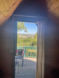an open door to a deck with a chair at Glamping in the 2nd Field in Aughrim
