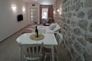a room with a table with a bottle of wine on it at APARTMENTs VISIT PERAST in Perast