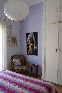 a bedroom with a bed and a painting of a girl at Sevasti Rafina in Rafina