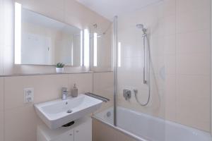 a white bathroom with a sink and a shower at Backauf in Bad Hindelang
