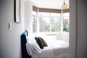 1 dormitorio con cama y ventana en Town Centre 4-bed House, en Harrow