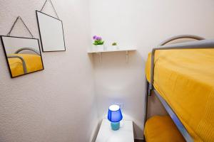 um quarto com uma cama amarela e um candeeiro azul em Casa Elda em Marina di Ragusa
