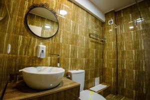 a bathroom with a sink and a toilet and a mirror at Bliss Inn Tunari in Tunari