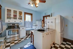 a kitchen with a white refrigerator and a stove at Downtown Victorian Home Near Lake Michigan Beach! in Manistee