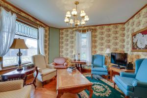 a living room filled with furniture and a chandelier at Downtown Victorian Home Near Lake Michigan Beach! in Manistee