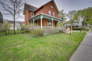 a large brick house with a fence in the yard at Downtown Victorian Home Near Lake Michigan Beach! in Manistee