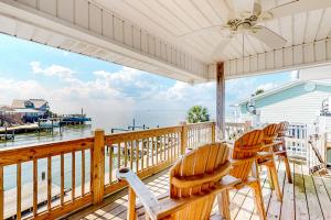 een veranda met schommelstoelen en uitzicht op het water bij Sounds Right in Dauphin Island