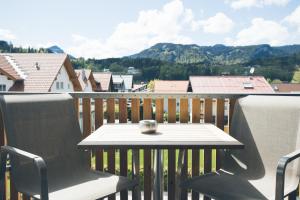 uma mesa e cadeiras numa varanda com vista em Apartmenthotel Oberstdorf em Oberstdorf