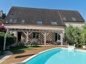 a house with a swimming pool in front of a house at La Relinquiere in Milhac