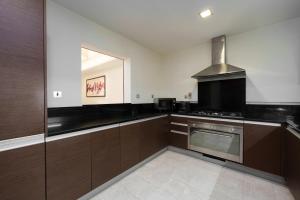 a kitchen with brown cabinets and a stove at Maison Privee - Charming Apt with Sea View on the Palm Jumeirah in Dubai
