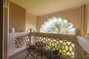 a balcony with a table and chairs and a window at Maison Privee - Charming Apt with Sea View on the Palm Jumeirah in Dubai