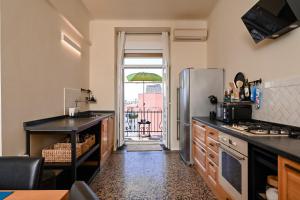 a kitchen with a refrigerator and a balcony with an umbrella at '2R' City Center Holidays and Workstays in Rijeka