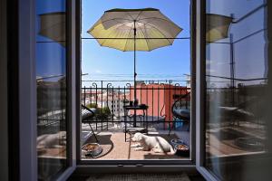 a white cat laying on a patio with an umbrella at '2R' City Center Holidays and Workstays in Rijeka