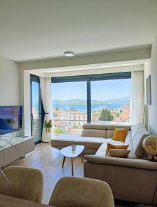 sala de estar con sofá y ventana grande en Apartment with a sea view., en Tivat