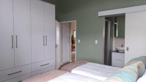 a bedroom with white cabinets and a bed at A Superb apartment in Still Bay in Stilbaai