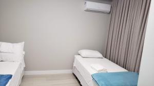 une petite chambre avec deux lits et une fenêtre dans l'établissement Maravilhoso frente mar, à Balneário Camboriú