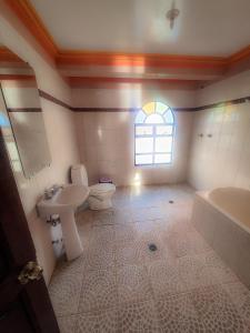 a bathroom with a sink and a toilet and a window at Hotel Chasqui del Sol in Copacabana