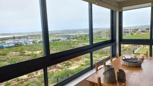 a dining room with a table with a view of the ocean at A Superb apartment in Still Bay in Stilbaai