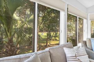a living room with a couch and a large window at 507 Tarpon Pond Cottage in Johns Island