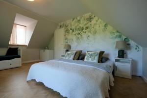 sypialnia z białym łóżkiem z kwiatami na ścianie w obiekcie Pokoje Irys w Kazimierzu Dolnym