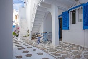 a street with white buildings and blue shutters at Nice & Cosy Mykonos studios in Megali Ammos