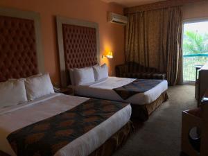 a hotel room with two beds and a window at Santana Hotel Cairo in Cairo