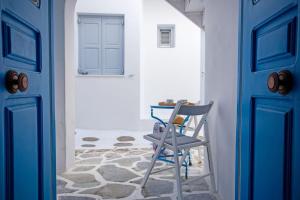 a blue door and a chair in a hallway at Nice & Cosy Mykonos studios in Megali Ammos +9 photos