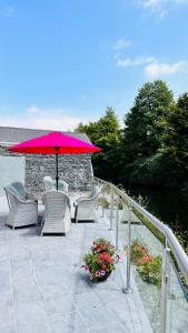un patio con sillas, sombrilla y flores en Shandon Bells Guest House, en Cork