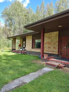 een huis met een veranda en een grasveld bij Villa Maria in Varkaus