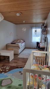 ein Schlafzimmer mit 2 Betten und einem Kinderbett in der Unterkunft Villa Maria in Varkaus