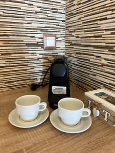 two coffee cups sitting on a table with a toaster at Katerina Apartments & Studios in Naousa
