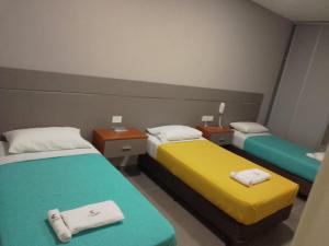 - une chambre avec 2 lits et des serviettes dans l'établissement ALOJAMIENTO CENTENARIO, à Corrientes