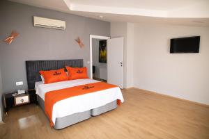 イスタンブールにあるZOOM HOTELのベッドルーム1室(オレンジ色の枕とテレビ付)