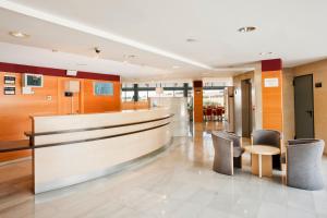 a lobby with a counter and chairs in a building at Hotel Holiday Inn Express Madrid-Rivas, an IHG Hotel in Rivas-Vaciamadrid