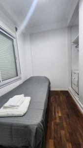 Bett in einem Zimmer mit Fenster und Holzböden in der Unterkunft Departamento Shoping Alto Noa in Salta